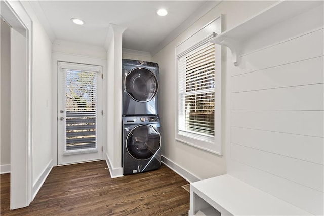 washroom with crown molding, baseboards, dark wood-type flooring, laundry area, and stacked washer / drying machine