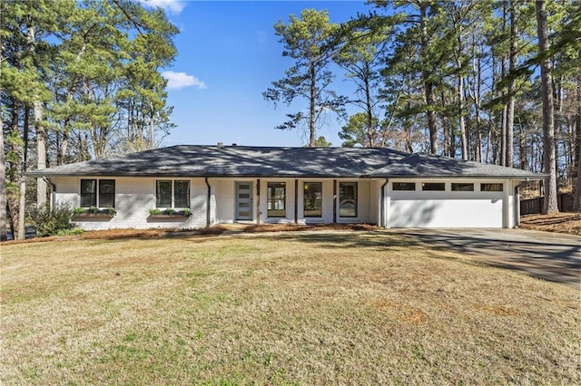 ranch-style home with a front lawn, brick siding, a garage, and driveway