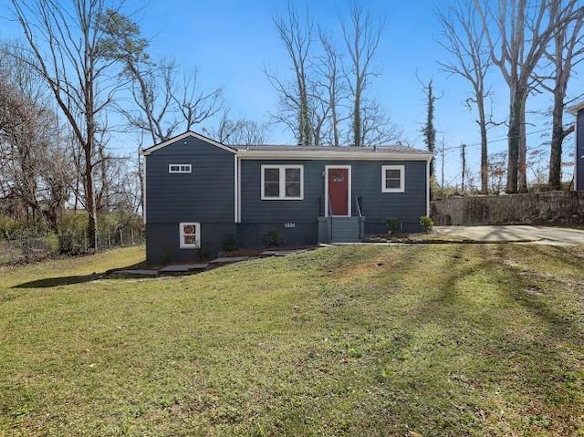 view of front of home with entry steps, a front lawn, and fence