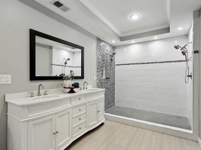 full bath with a sink, visible vents, wood finished floors, and crown molding