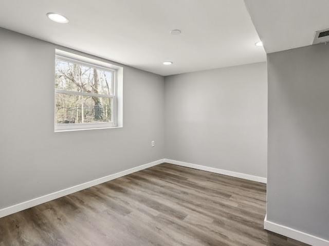 empty room featuring recessed lighting, baseboards, and wood finished floors