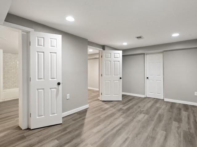 finished basement featuring visible vents, recessed lighting, baseboards, and wood finished floors