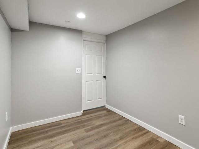 empty room with recessed lighting, baseboards, and wood finished floors