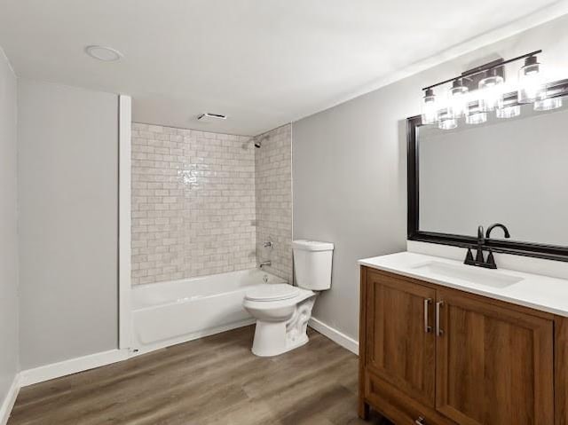 bathroom with vanity, wood finished floors, baseboards, shower / washtub combination, and toilet