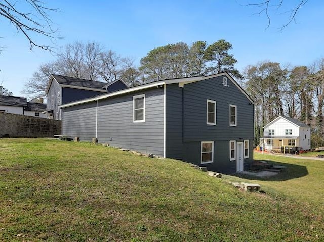 view of home's exterior with a lawn and fence