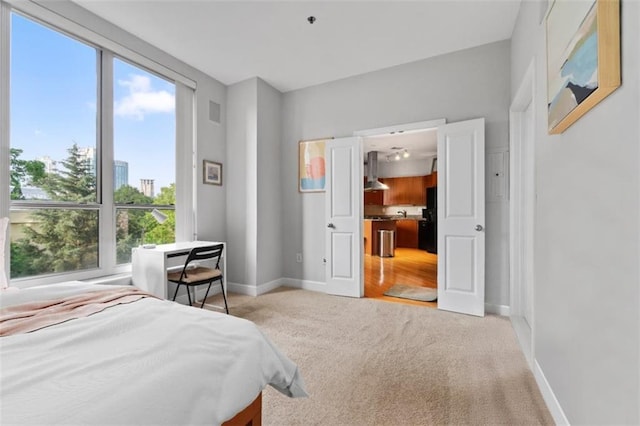 2626 Peachtree Rd NW Unit 606, Atlanta, GA 30305 - bedroom featuring freestanding refrigerator, baseboards, light colored carpet, and multiple windows