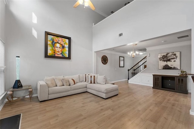 living room featuring crown molding, light hardwood / wood-style floors, and a high ceiling