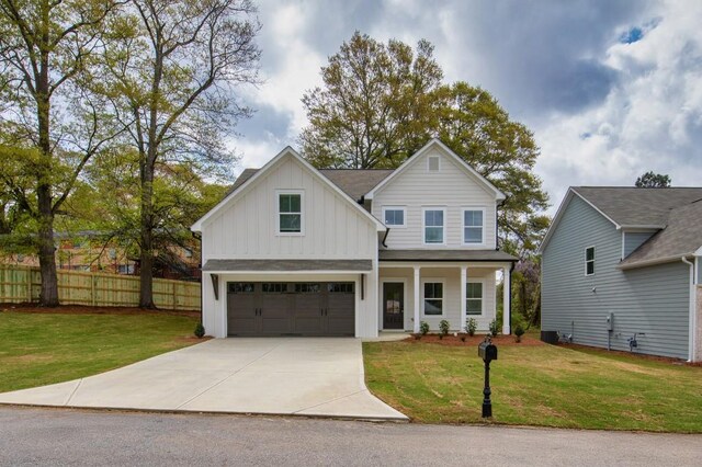 view of front of house with board and batten siding, a patio area, a garage, and a shingled roof