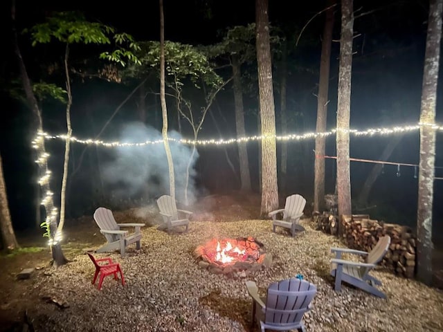 yard at night featuring an outdoor fire pit