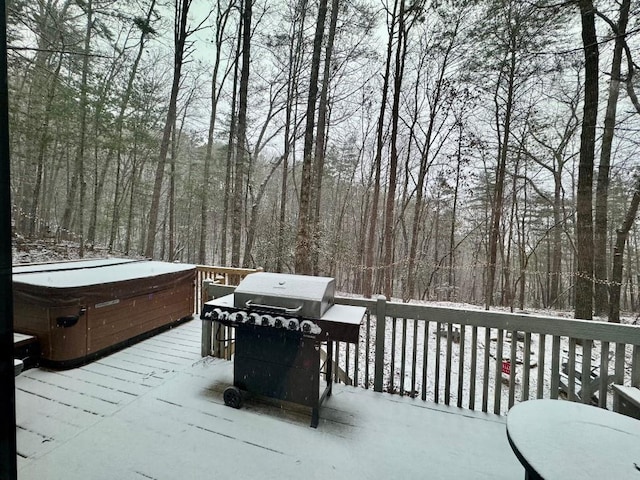 wooden terrace with area for grilling, a view of trees, and a hot tub