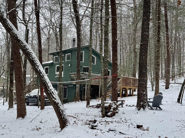 exterior space featuring stairway, a deck, and a chimney