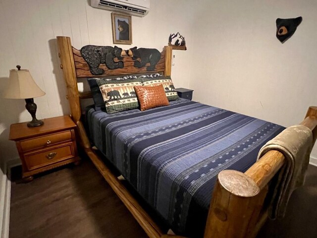 bedroom with dark wood-type flooring and an AC wall unit