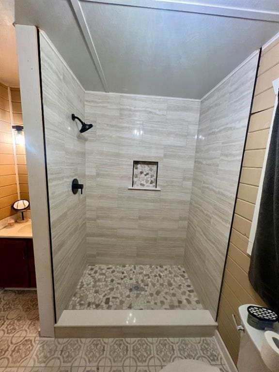 full bathroom with a tile shower, tile patterned flooring, and tile walls