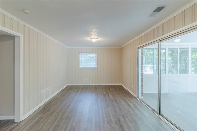 738 Laverne Dr NW, Atlanta, GA 30318 - empty room featuring wood finished floors, plenty of natural light, baseboards, visible vents, and crown molding