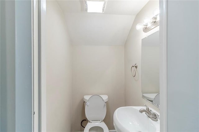 738 Laverne Dr NW, Atlanta, GA 30318 - bathroom with toilet, vaulted ceiling, and a sink