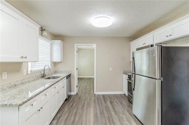 738 Laverne Dr NW, Atlanta, GA 30318 - kitchen featuring appliances with stainless steel finishes, white cabinets, light wood finished floors, and a sink
