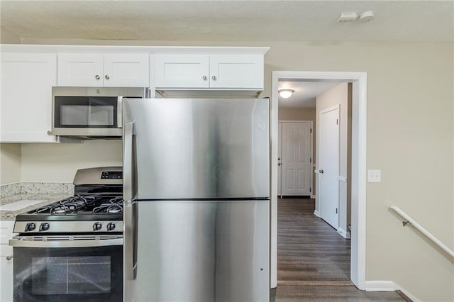 738 Laverne Dr NW, Atlanta, GA 30318 - kitchen featuring white cabinets, appliances with stainless steel finishes, wood finished floors, and baseboards