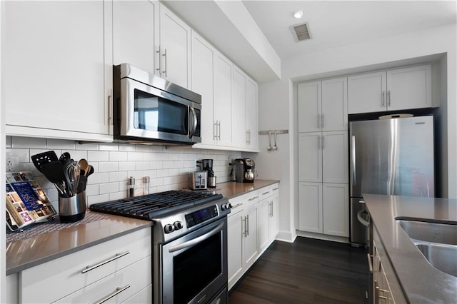 1100 Howell Mill Rd NW Unit 708, Atlanta, GA 30318 - kitchen featuring stainless steel appliances, dark wood-style floors, decorative backsplash, white cabinetry, and recessed lighting