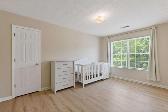1450 Steam Engine Way, Conyers, GA 30013 - bedroom featuring light wood-type flooring, baseboards, and a textured ceiling