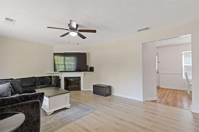 1450 Steam Engine Way, Conyers, GA 30013 - living area with ceiling fan, wood finished floors, a glass covered fireplace, a textured ceiling, and baseboards