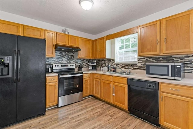 1450 Steam Engine Way, Conyers, GA 30013 - kitchen with black appliances, under cabinet range hood, a sink, light countertops, and light wood-type flooring