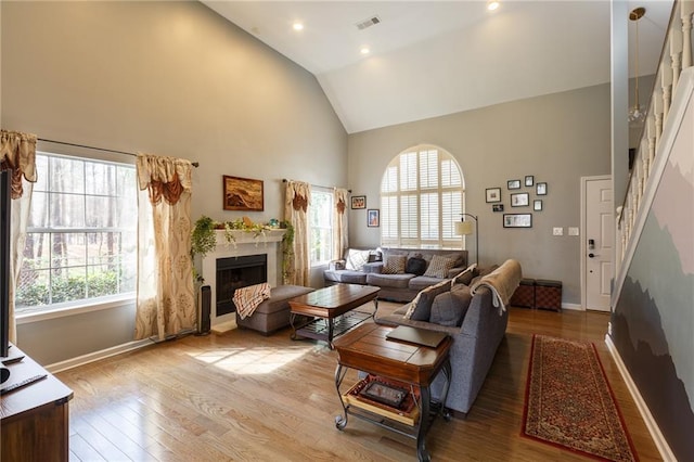 living room featuring high vaulted ceiling, plenty of natural light, and wood-type flooring