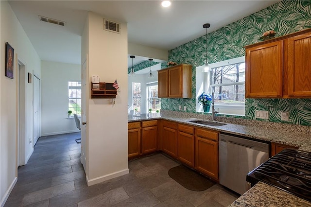 kitchen with sink, plenty of natural light, pendant lighting, stainless steel dishwasher, and light stone countertops