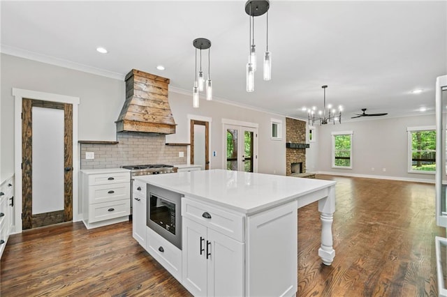 4189 Tamarack Dr, Jasper, GA 30143 - kitchen with custom range hood, stainless steel microwave, light countertops, a center island, and ornamental molding