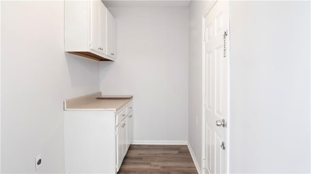 clothes washing area with dark wood-type flooring