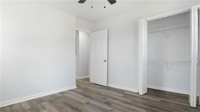 unfurnished bedroom featuring ceiling fan, dark wood-type flooring, and a closet