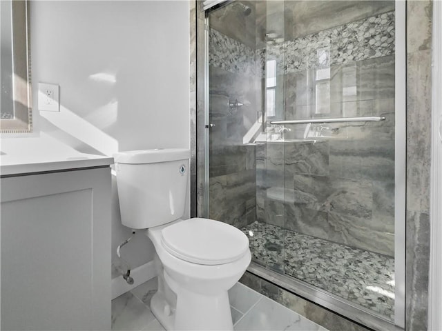 bathroom featuring toilet, vanity, and a shower with shower door