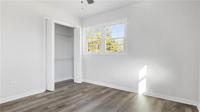 unfurnished bedroom with ceiling fan, dark wood-type flooring, and a closet