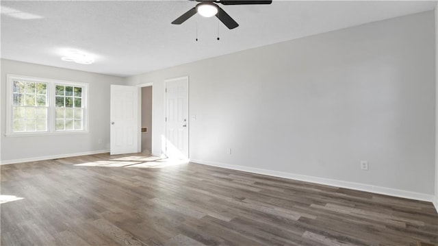 empty room featuring ceiling fan and dark hardwood / wood-style flooring