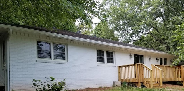 back of property with a wooden deck and brick siding