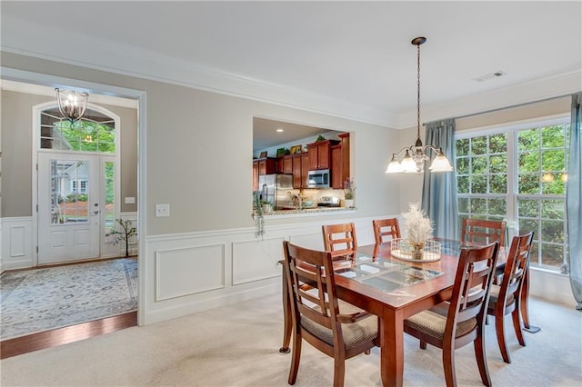 4460 Delano Dr, Cumming, GA 30040 - dining room featuring a chandelier, crown molding, a wainscoted wall, a decorative wall, and light colored carpet