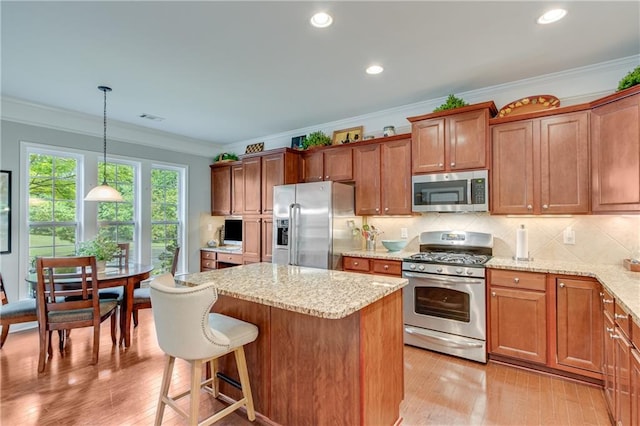 4460 Delano Dr, Cumming, GA 30040 - kitchen featuring stainless steel appliances, a kitchen island, ornamental molding, backsplash, and light wood-style floors