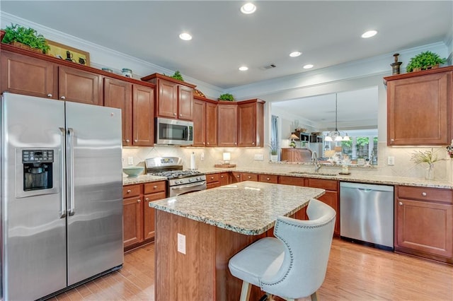 4460 Delano Dr, Cumming, GA 30040 - kitchen with appliances with stainless steel finishes, a sink, ornamental molding, light wood finished floors, and light stone countertops
