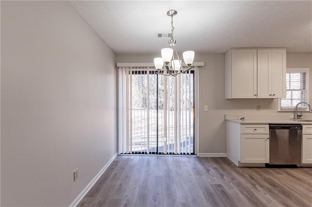 kitchen featuring white cabinetry, dishwasher, sink, and pendant lighting