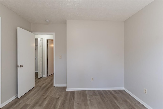 spare room featuring a textured ceiling and light wood-type flooring