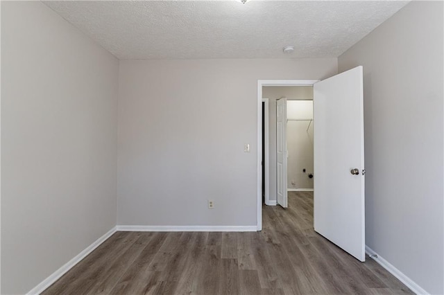 empty room with hardwood / wood-style flooring and a textured ceiling