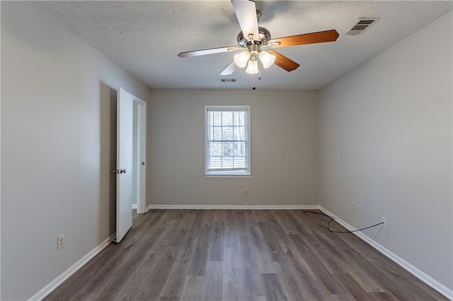 spare room with ceiling fan, dark wood-type flooring, and a textured ceiling