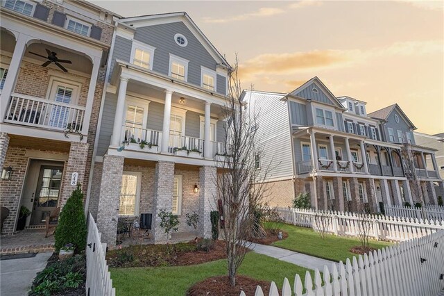 view of front of property featuring a balcony and a front yard