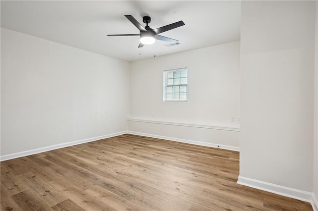 unfurnished room featuring ceiling fan, wood finished floors, visible vents, and baseboards