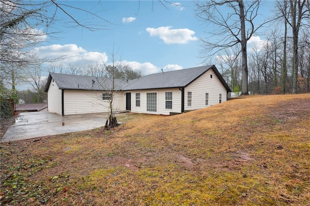 rear view of house featuring a yard and a patio area