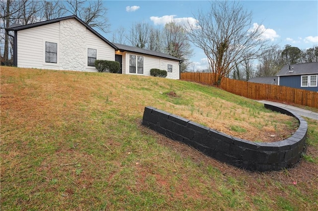 exterior space featuring a lawn and fence