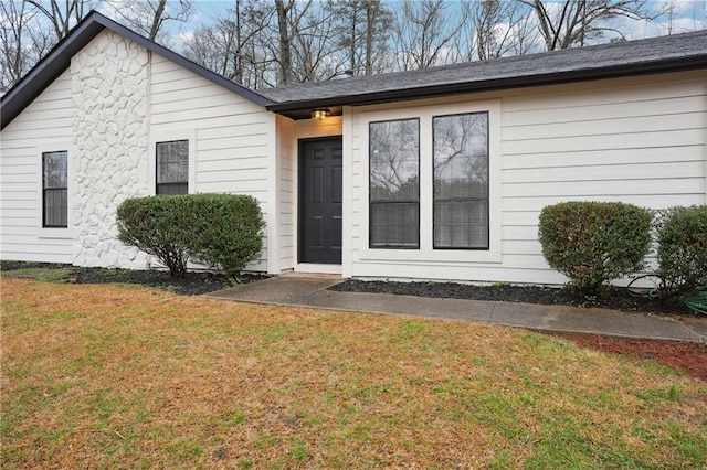 doorway to property with a yard