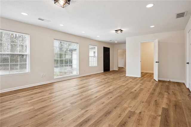 empty room featuring light wood finished floors, visible vents, recessed lighting, and baseboards