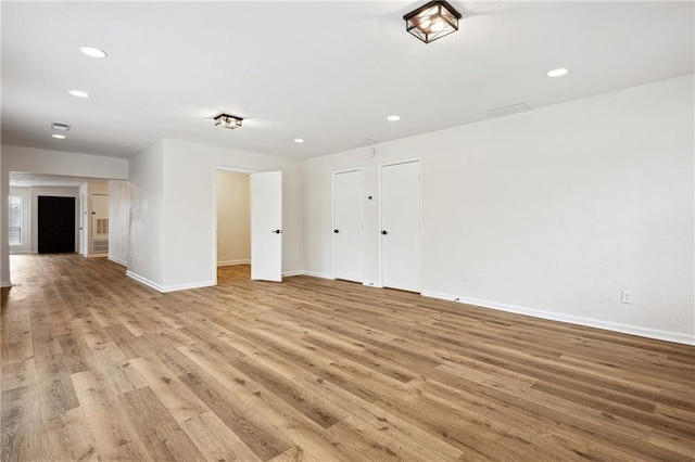 spare room featuring visible vents, recessed lighting, light wood-type flooring, and baseboards