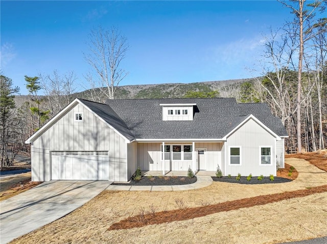 modern farmhouse style home with driveway, board and batten siding, covered porch, an attached garage, and roof with shingles