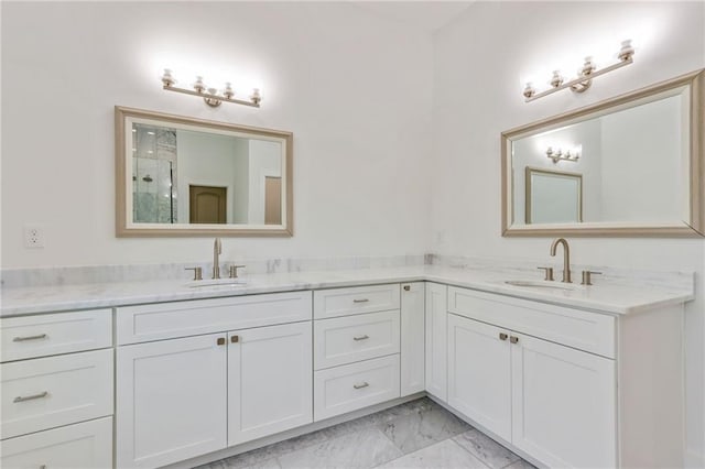 bathroom featuring double vanity, marble finish floor, and a sink